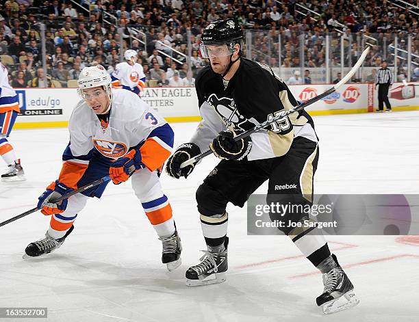 Dustin Jeffrey of the Pittsburgh Penguins skates alongside Travis Hamonic of the New York Islanders on March 10, 2013 at Consol Energy Center in...
