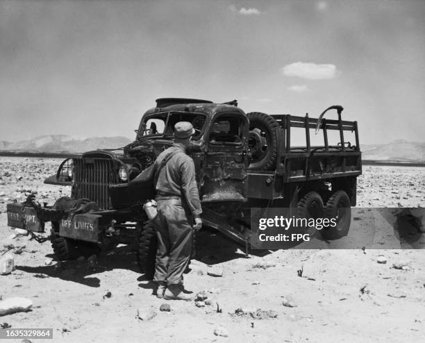 American military personnel inspect a truck during an inspection of atomic test equipment following an A-bomb explosion at the Nevada Proving...