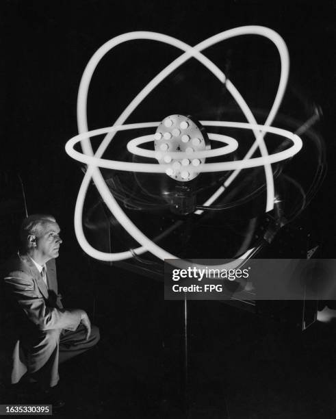 American research scientist Dr Richard C Hitchcock beside his model of an atom, which has been magnified billions of times, comprising eight...