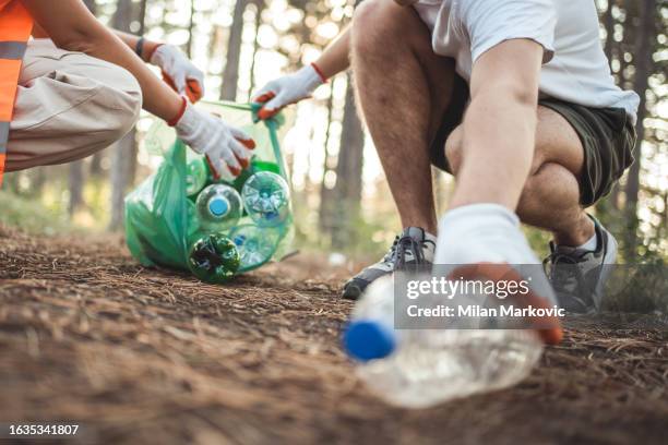 a group of teenagers jointly contributes to the preservation of the environment by collecting waste from nature. their actions express engagement, responsibility and care for the environment. - earth activist stock pictures, royalty-free photos & images