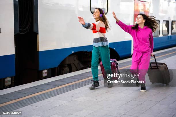 girls whit luggage running to catch the train at the station - catching train stock pictures, royalty-free photos & images