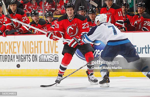 Derek Meech of the Winnipeg Jets and David Clarkson of the New Jersey Devils battle for control of the puck during the game at the Prudential Center...