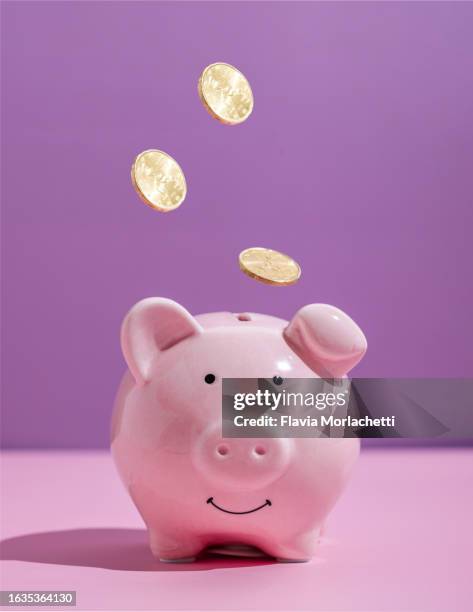 coins falling into piggy bank - spaarpot financieel item stockfoto's en -beelden