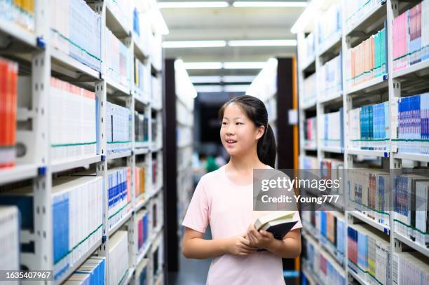 asian junior high school student borrowing books in public library - chinese girl stock pictures, royalty-free photos & images