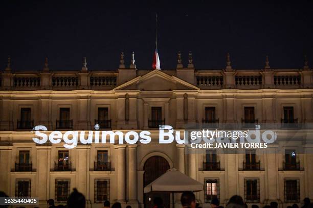 The phrase "We are still searching" is projected on the facade of the Palacio de La Moneda in Santiago on August 30 the day on which Chile's...