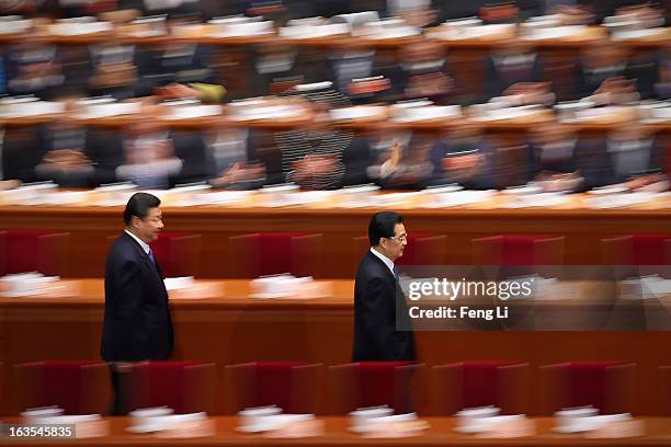 Chinese Communist Party chief and incoming-President Xi Jinping walks behind Chinese President Hu Jintao as they arrive for the closing session of...