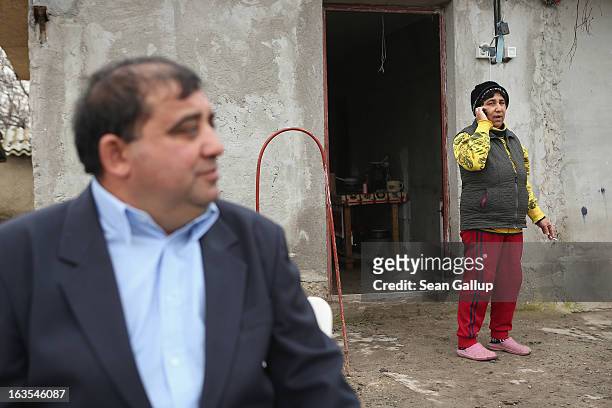 Aneta Enache , an ethnic Roma, talks on her mobile phone outside her home during a visit by her brother Georghe Percu on March 11, 2013 in Dilga,...