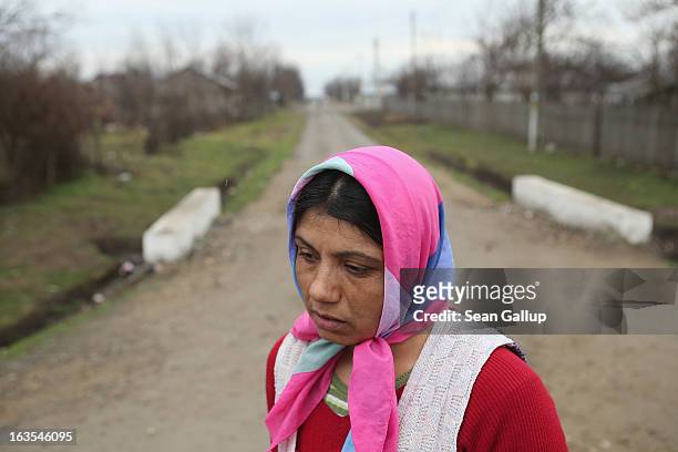 Ethnic Roma Tudora Tanase pauses while walking down a dirt road on March 11, 2013 in Dilga, Romania. Tudora works as a cleaning woman at a university...
