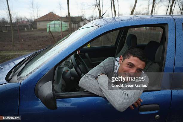 Vasile Nedelcu, who is an ethnic Roma, smiles from his car on March 11, 2013 in Dilga, Romania. Vasile's mother works in Italy as a senior care...