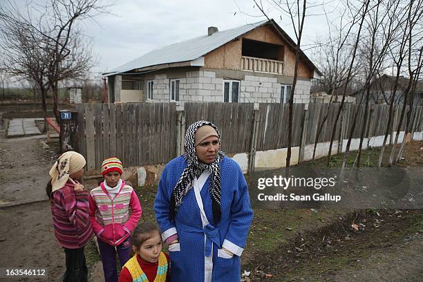 Ethnic Roma Mirela Tudor and three of her five children stand outside the new house her partner Mitica Tenase built on March 11, 2013 in Dilga,...