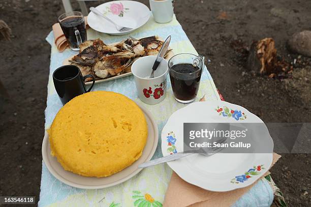 Lunch of fried fish and mamaliga, a traditional Romanian dish made from cornmeal, awaits a visitor outside the home of Aneta and Constantin Enache,...