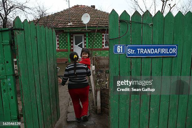 Viorica Gheorghe, who is an ethnic Roma, holds her daughter Gabriela while she leads a visitor to her home on March 11, 2013 in Dilga, Romania....