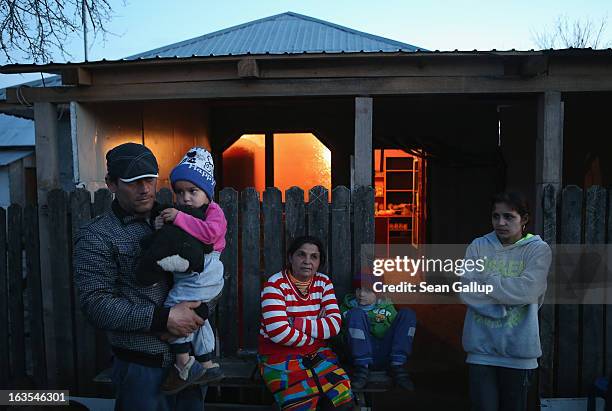 Ethnic Roma Xenia Costea , her father and other members of her family stand outside the small grocery shop she runs on March 11, 2013 in Dilga,...