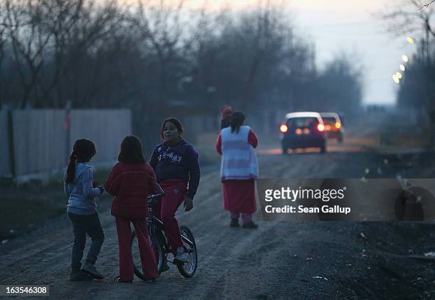 Ethnic Roma children chat on one of the residential streets after sundown on March 11, 2013 in Dilga, Romania. Dilga is a settlement of 2,500 people...