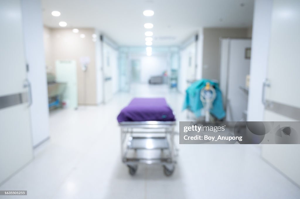 Blurred image background of an emergency stretcher without patient in hospital corridor.