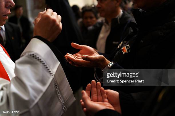 People receive communion while attending the Pro Eligendo Romano Pontifice Mass at St Peter's Basilica, after which Cardinals will enter the conclave...