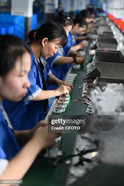 Workers work on a circuit breaker production line at an electric company workshop in Fuyang city, Anhui province, China, August 30, 2023. China's...