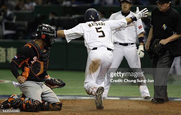 Infielder Nobuhiro Matsuda of Japan safely reaches home base as catcher Quintin De Cuba of Netherlands looks on in the eighth inning during the World...