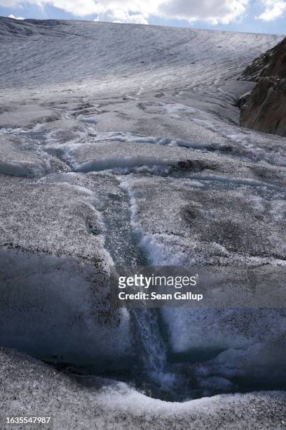 Rivulet of water pours into a small crevasse on the tongue of the melting Gepatschferner glacier on August 22, 2023 above Kaunertal, Austria. Martin...