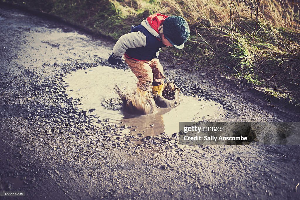 Child jumping in a puddle