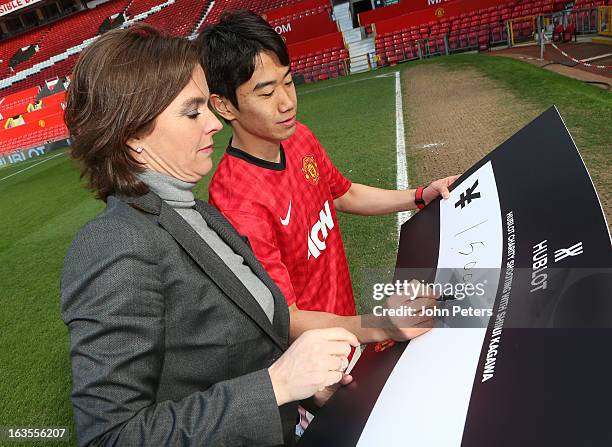 Shinji Kagawa of Manchester United is presented with a cheque for 3 000 Japanese Yen by Valerie Servageon Grande of Hublot watches after taking part...