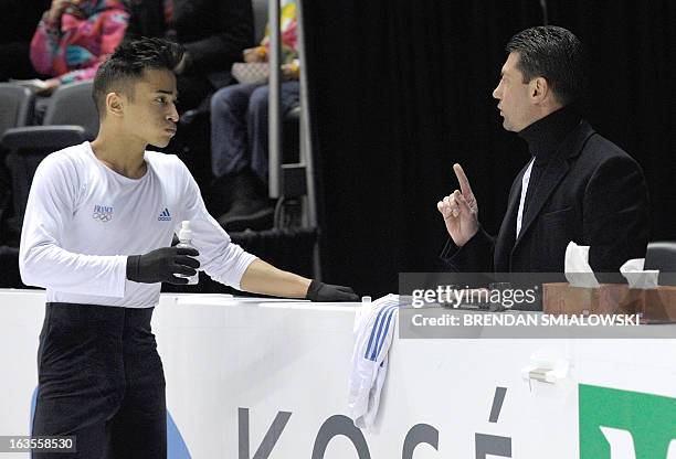 Florent Amodio competing for France speaks with his coach Nikolai Morozov while practicing at Budweiser Gardens in preparation for the 2013 World...