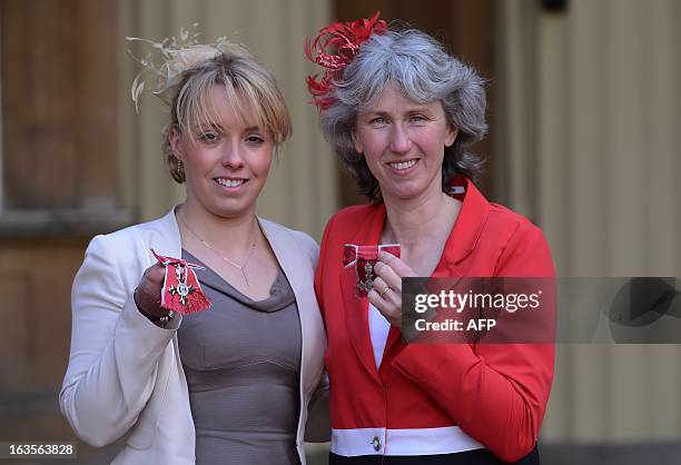 Paralympians Sophie Wells and Deborah Criddle pose for photographs after they received an MBE's at Buckingham Palace in London on March 12, 2013. AFP...