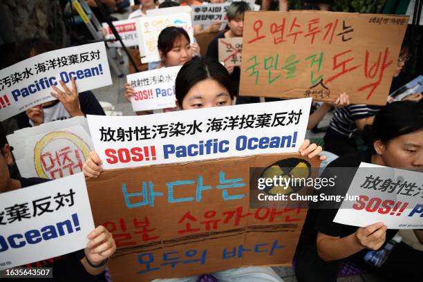 Protesters participate in a rally against the release of treated radioactive water from the damaged Fukushima nuclear power plant into the Pacific...