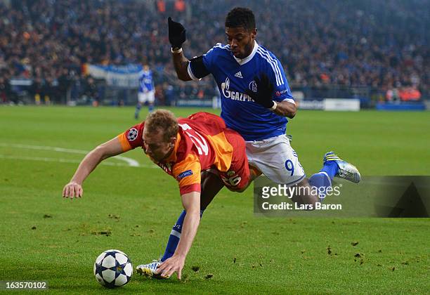 Michel Bastos of Schalke challenges Semih Kaya of Galatasaray during the UEFA Champions League round of 16 second leg match between FC Schalke 04 and...