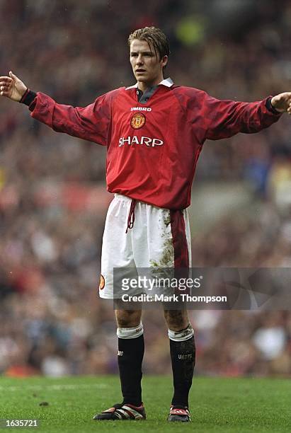 David Beckham of Manchester United stands with his arms outstretched during an FA Carling Premiership match against Wimbledon at Old Trafford in...
