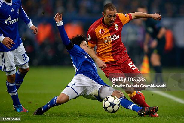 Atsuto Uchida of Schalke challenges Nordin Amrabat of Galatasaray during the UEFA Champions League round of 16 second leg match between Schalke 04...