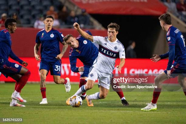 Vancouver Whitecaps midfielder Sebastian Berhalter maneuvers the ball away from Chicago Fire midfielder Xherdan Shaqiri and Chicago Fire midfielder...