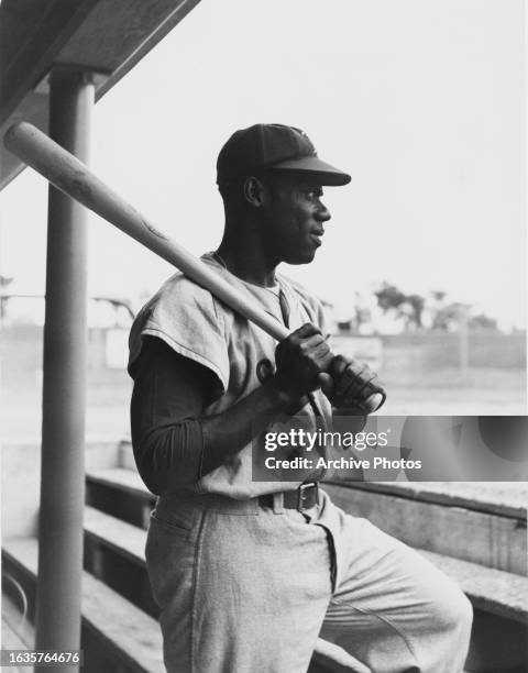 Portrait of Clyde Parris from Panama and Infielder for the Montreal Royals holding his bat and looking on from the dugout during Minor League...