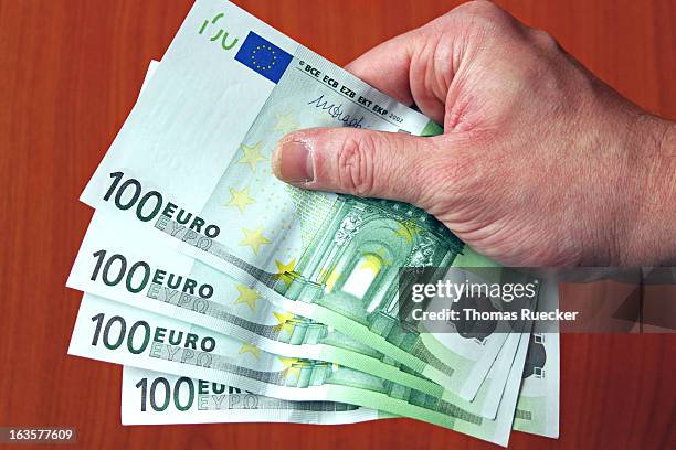 paying euro bank notes - one hundred euro banknote stock pictures, royalty-free photos & images