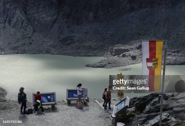 Visitors stand at a spot where in 1960 the Pasterze, Austria's biggest glacier, lay just below on August 21, 2023 near Heiligenblut, Austria. Today...