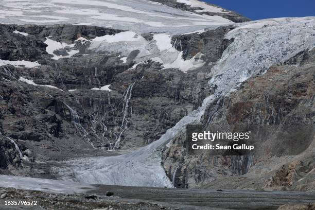 Water falls from the Pasterze, Austria's biggest glacier, as the glacier tongue descends on the right on August 21, 2023 near Heiligenblut, Austria....