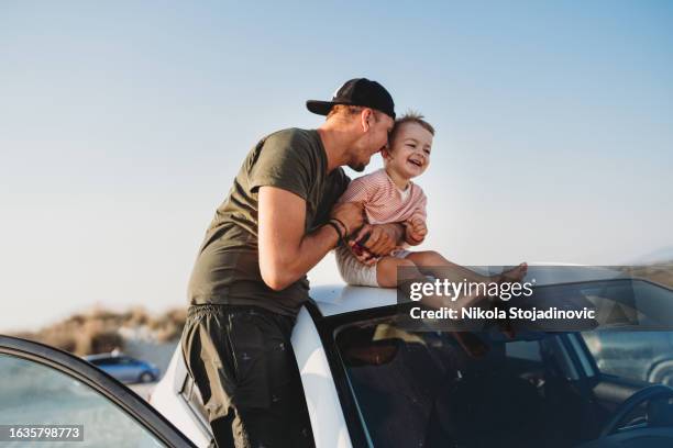 young father and his son sitting on the roof of his car - mellan 30 och 40 bildbanksfoton och bilder
