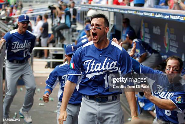 Alex Liddi of Team Italy celebrates in the dugout after Chris Colabello hits a three-run home run in the top of the first inning of Pool 2, Game 1...