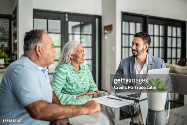 asesor financiero que tiene una reunión con una pareja mayor en casa - cliente fotografías e imágenes de stock