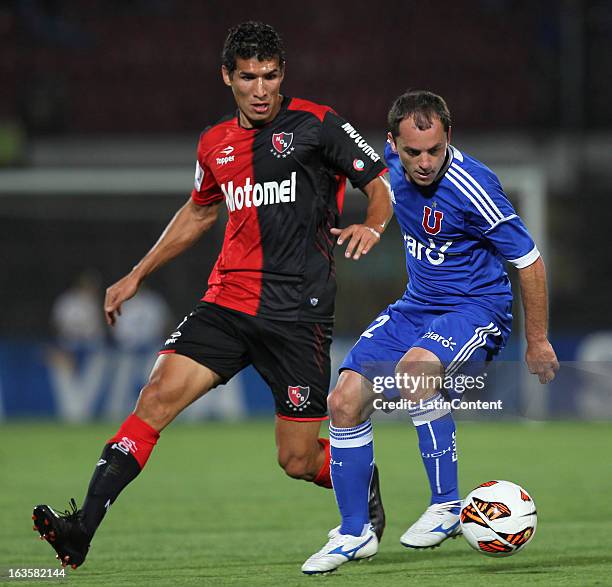 Gustavo Lorenzetti of Universidad de Chile struggles for the ball with Marcos Caceres of Newell's Old Boys during a match between Universidad de...