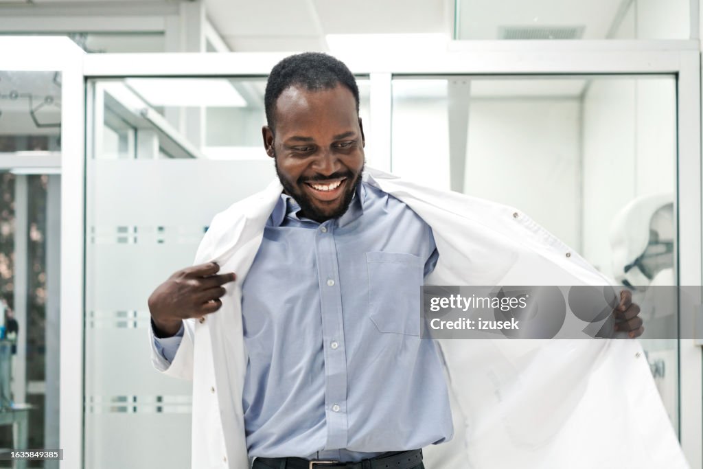 Smiling male medical worker wearing lab coat while standing in laboratory