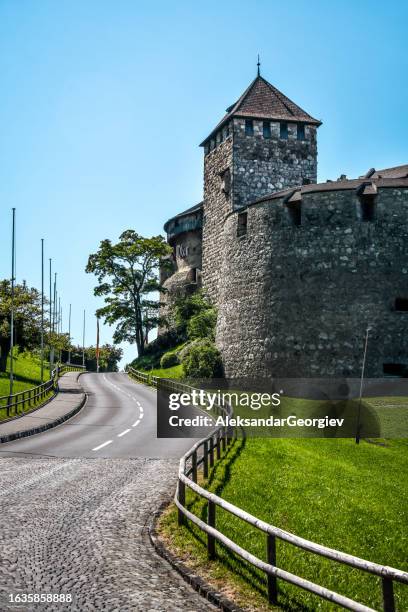 asphaltstraße neben schloss vaduz in vaduz, liechtenstein - vaduz castle stock-fotos und bilder