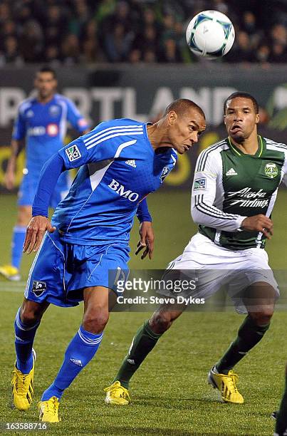 Matteo Ferrari of Montreal Impact heads a ball as Ryan Johnson of Portland Timbers looks on during the second half of the game at Jeld-Wen Field on...