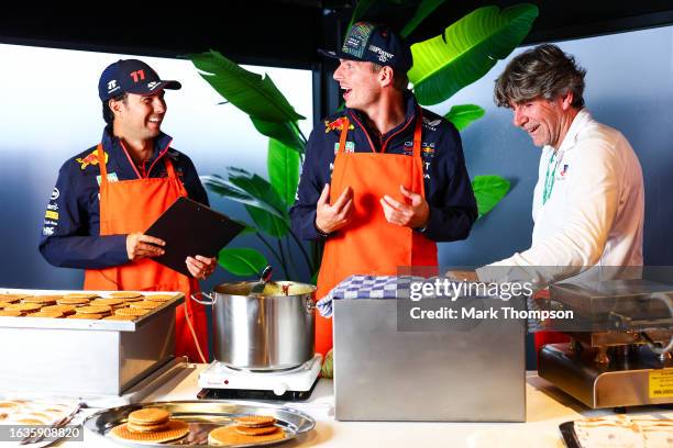 Sergio Perez of Mexico and Oracle Red Bull Racing and Max Verstappen of the Netherlands and Oracle Red Bull Racing cook stroopwafels in the Paddock...