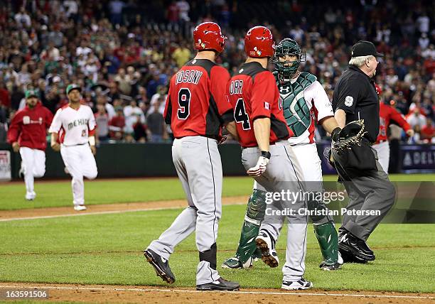 Catcher Sebastian Valle of Mexico reacts to Pete Orr and Rene Tosoni of Canada as both teams run onto the field during the World Baseball Classic...