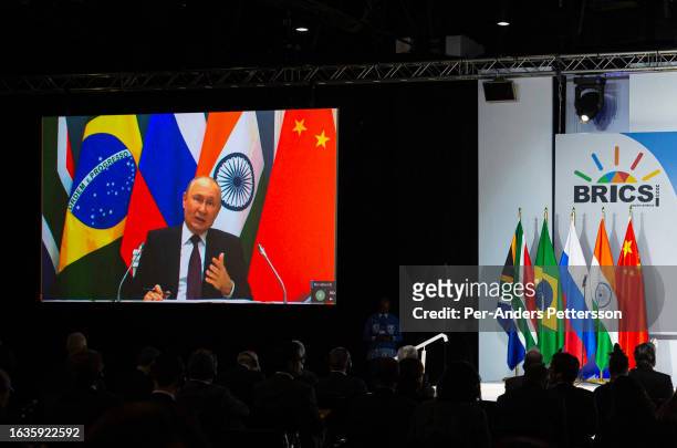 Russia's president Vladimir Putin speaks via video link during a press conference on the closing day of The BRICS summit at the Sandton Convention...