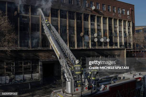 Firefighters extiguish a fire in a building in Johannesburg on August 31, 2023. More than 60 people have died in a fire that engulfed a five-storey...