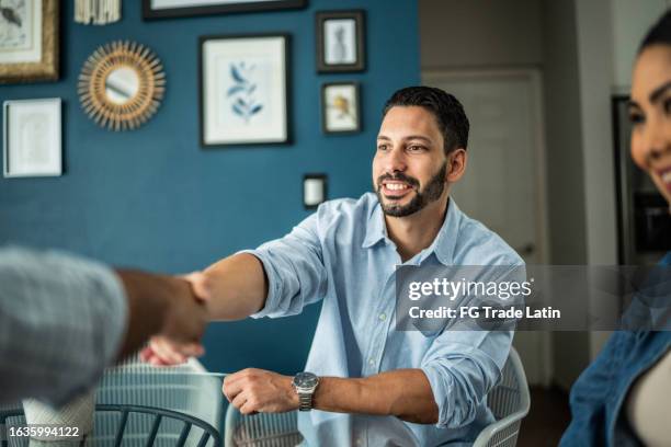 male customer shaking hands with real estate agent or financial advisor at home - closing sale stock pictures, royalty-free photos & images