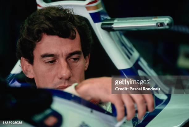 Ayrton Senna from Brazil looks out from the cockpit of the Rothmans Williams Renault Williams FW16 Renault V10 in the garage and adjusts the wing...