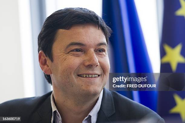 French economist Thomas Piketty smiles during a meeting at the National Assembly on March 13, 2013 in Paris. AFP PHOTO / FRED DUFOUR